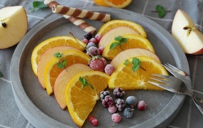 Orange slices with apple and frozen berries