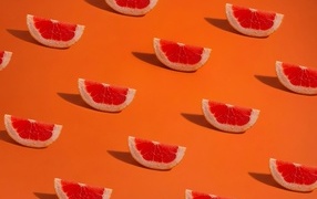 Pieces of grapefruit on an orange background