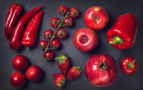 Red vegetables and fruits on a gray table