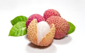 Ripe lychee with green leaves isolated on white background