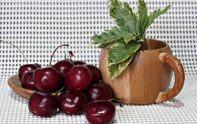 Ripe red cherries on the table with a flower
