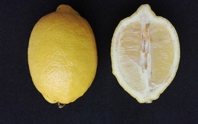 Разрезанный лимон на черном столе
