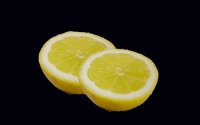 Two halves of lemon on a black background