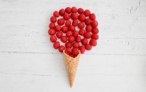Waffle cone with raspberries on a white table