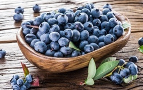 Wooden plate with blueberries on the table