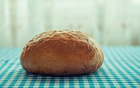 Круглая буханка хлеба лежит на столе