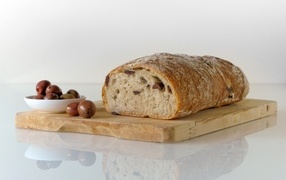 Fresh bread with olives on a cutting board