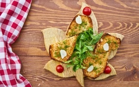 Fried bread on a board with herbs and tomatoes