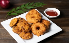 Pastries on a plate on the table with sauce and leaf