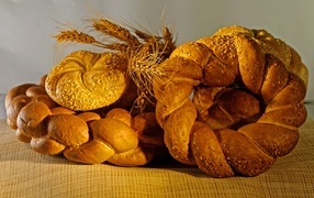 Spikelets of fresh bread on a table with wheat