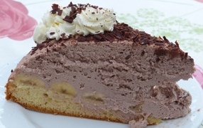 Кусок аппетитного торта с кремом на белой тарелке