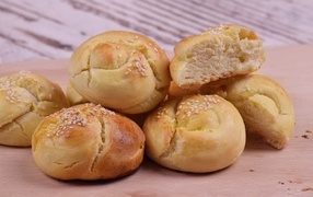 Аппетитные сладкие булочки с кунжутом на столе