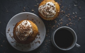 Пирожное в тертым шоколадом на столе с чашкой кофе