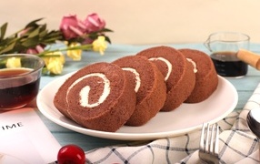 Шоколадный бисквитный рулет с кремом на тарелке