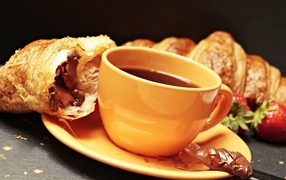 Чашка кофе на тарелке с круассанами