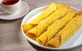 Вкусные сладкие трубочки с чаем на столе