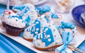 Пряники в форме сердца на палочке с кексами на столе