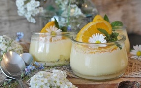 Лимонный крем в стеклянных банках на столе с цветами