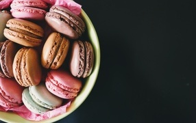 Десерт макарун в миске на черном фоне