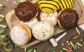 Много сладких пончиков в глазури на столе