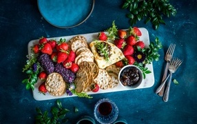 Plate with cookies, cheese and strawberries