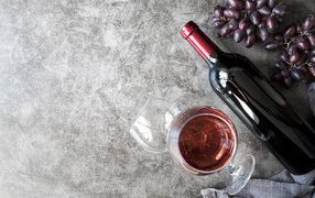 Бутылка красного вина с бокалами на столе