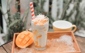 Коктейль с манго в стакане на столе