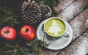 Чашка кофе на столе с яблоками и шишками