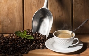 Cup of coffee on the table with aromatic beans