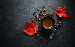 Cup of coffee on the table with grains and yellow leaves