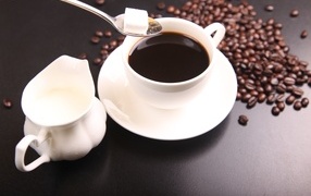 Cup of coffee on the table with milk and sugar