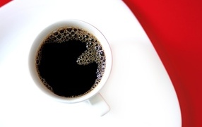 Чашка горячего черного кофе на столе 