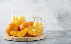 Свежевыжатый сок на столе с апельсинами