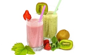Fruit smoothies in glasses on the table with strawberries and kiwi