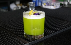 Green cocktail in a glass with flowers