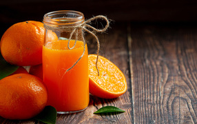 Банка свежего сока на столе с мандаринами
