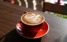 Латте с красивой пенкой в красной чашке
