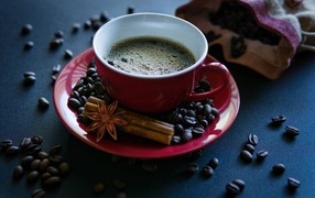 Красная чашка кофе на столе со специями и зернами