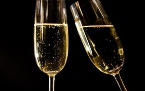 Two glasses of champagne on a black background