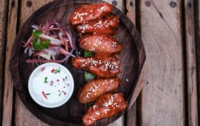 Baked chicken wings with sauce on a plate