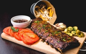 Baked ribs on a board with vegetables