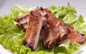 Grilled ribs with green salad leaves