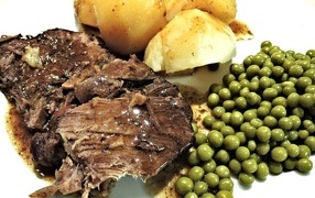 Piece of meat with potatoes and green peas