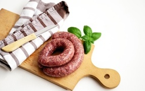 Raw sausage on a board with a knife