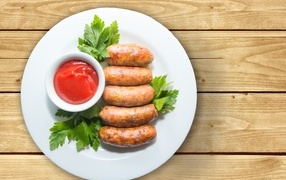 Sausages on a plate with sauce and parsley