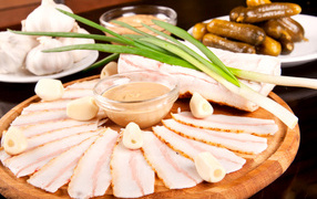 Sliced lard with garlic and pickles on the table