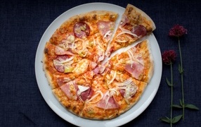 Нарезанная пицца на белой тарелке