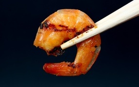 Fried shrimp with chopsticks on a black background
