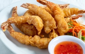 Shrimp in batter on a plate with salad and sauce