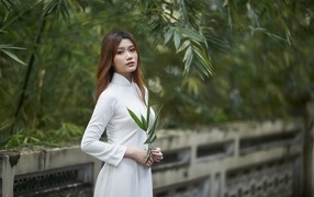 Девушка азиатка в белом наряде в парке